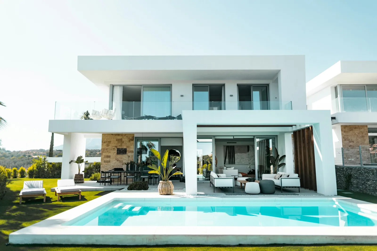 Contemporary white villa with large glazing and a pool, representing architectural design